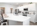 Bright kitchen featuring white cabinets, stainless steel appliances, and quartz countertops at 706 Bentley North Loop, Auburndale, FL 33823