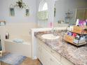 Bright bathroom featuring a bathtub, vanity with granite countertop, decorative mirror, and ample space for storage at 7965 Kaitlin Cir, Lakeland, FL 33810