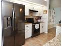 Modern kitchen featuring stainless steel appliances, granite countertops, white cabinetry, and tile backsplash at 7965 Kaitlin Cir, Lakeland, FL 33810