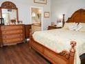 Comfortable main bedroom with a decorative wood bed frame, matching dressers, and access to the ensuite bathroom at 7965 Kaitlin Cir, Lakeland, FL 33810