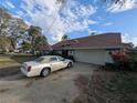 Spacious home exterior with a two-car garage and long driveway at 838 Lakeshore Dr, Polk City, FL 33868