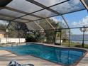 Refreshing screened-in pool area with a view of the lake at 838 Lakeshore Dr, Polk City, FL 33868