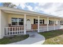 Inviting front porch with brick accents, white railing, and a clear view of the home's entrance at 144 Lowell Rd, Winter Haven, FL 33884