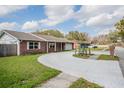 The wide driveway accesses the garage of this single-story brick house at 144 Mirror Nw Ln, Winter Haven, FL 33881