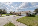 The brick home has a large concrete driveway leading to a two-car garage at 144 Mirror Nw Ln, Winter Haven, FL 33881