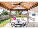 Covered patio area with a ceiling fan, dining table, and grill for outdoor entertaining at 144 Mirror Nw Ln, Winter Haven, FL 33881