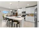 Bright kitchen with an island, stainless steel appliances, and an adjacent dining area perfect for entertaining at 2027 Airedale Way, Lake Alfred, FL 33850