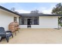 Back patio with furniture, a screened door, and white exterior walls at 2326 Eastmeadows Rd, Lakeland, FL 33812