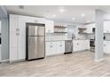 Spacious kitchen boasts white cabinets, stainless steel appliances, granite countertops and laminate flooring at 2521 Coral Way, Lakeland, FL 33801
