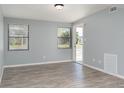 Bright living room features two windows, neutral walls, and durable laminate flooring creating a modern aesthetic at 2521 Coral Way, Lakeland, FL 33801