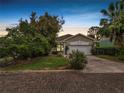 Charming single-story home featuring a stucco exterior, well-manicured lawn, and an attached two-car garage at dusk at 2616 Fairmount Ave, Lakeland, FL 33803