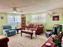 Inviting living room featuring large windows, carpet flooring, and a ceiling fan, creating a comfortable space at 3023 Maplewood Ave, Lakeland, FL 33803