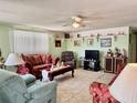 Cozy living room with carpet flooring, ceiling fan, and decorative shelving highlighting personal touches at 3023 Maplewood Ave, Lakeland, FL 33803