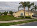 Attractive townhome with a two-car garage, lush landscaping, and mature palm trees at 4010 Winding Vine Dr # 4010, Lakeland, FL 33812