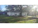 View of the house showing mature trees in the front yard and a glimpse of the neighborhood at 406 Fox Lake Dr, Lakeland, FL 33809