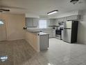 Bright kitchen features gray cabinets, stainless steel appliances, breakfast bar, and light tile flooring at 406 Fox Lake Dr, Lakeland, FL 33809