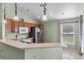 Functional kitchen featuring tile floors, stainless steel appliances, ample counter space, and wooden cabinets at 4688 Hickory Stream Ln, Mulberry, FL 33860