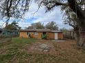 Back of a cozy single-story home featuring a well-kept yard with mature tree and landscaping at 475 W Ethelene St, Bartow, FL 33830