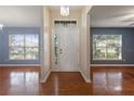 Bright foyer with hardwood floors, white door, and natural light from large windows at 560 Hatchwood Dr, Haines City, FL 33844