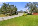 Suburban home with a sprawling green lawn and long driveway leading to the two-car garage at 560 Hatchwood Dr, Haines City, FL 33844