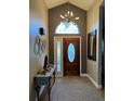 Inviting entryway featuring a high ceiling, decorative chandelier, and stylish wooden front door at 5982 Crane Dr, Lakeland, FL 33809