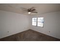 Carpeted bedroom with a ceiling fan, window and neutral paint providing a calm retreat at 6055 Topher Trl # 6055, Mulberry, FL 33860