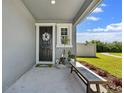 Inviting front porch with a decorative wreath on the front door and bench seating at 6249 Great Bear Dr, Lakeland, FL 33805