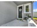 Close-up of the front porch with a decorative wreath on the front door and bench seating at 6249 Great Bear Dr, Lakeland, FL 33805