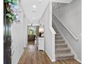 Bright entryway with hardwood floors, staircase, and open view into the living room at 6249 Great Bear Dr, Lakeland, FL 33805