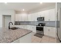 Bright kitchen with ample counter space, stainless steel appliances, and tile backsplash at 645 Sarner Pass Way, Winter Haven, FL 33881