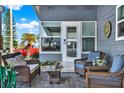 Covered porch with wicker seating creating a relaxing space to enjoy the outdoors at 6792 Brentwood Ne Dr, Winter Haven, FL 33881