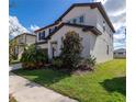 Side view of a two-story home with dark shutters and mature landscaping at 685 Meadow Pointe Dr, Haines City, FL 33844