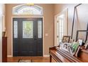 Elegant foyer features a decorative front door, transom window, and a grand piano at 7104 Lake Eaglebrooke Way, Lakeland, FL 33813