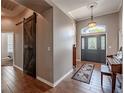 Inviting foyer features wood floors, a stylish barn door, and elegant lighting fixtures at 7104 Lake Eaglebrooke Way, Lakeland, FL 33813