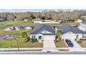 Aerial view of single-Gathering home showing landscaped yard, mature trees, and neighborhood pond at 7187 Cruz Ct, Lakeland, FL 33813