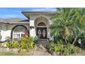 Close up of the front entrance, showcasing a tile entryway and lush landscaping at 7321 Gunstock Dr, Lakeland, FL 33809