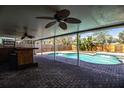 Covered patio with ceiling fans overlooking a pool and fenced backyard, creating an ideal outdoor living space at 7997 Kaitlin Cir, Lakeland, FL 33810