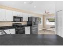 Efficient kitchen with modern black appliances, white cabinets and bright natural light from windows at 8350 Split Creek Cir, Lakeland, FL 33809