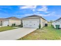 A well-kept home with a two-car garage, green lawn, a concrete driveway and manicured landscaping at 965 Eagle Rock Ter, Winter Haven, FL 33880