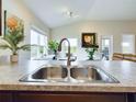 A stainless steel double kitchen sink with a view to the backyard at 1134 Legatto Loop, Dundee, FL 33838
