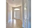 Bright entryway with tile flooring, a transom window, and white doors for a welcoming entrance at 136 Krenson Bay Loop, Winter Haven, FL 33881