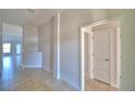 Neutral hallway featuring tile floors and white trim, offering a clean, modern aesthetic at 136 Krenson Bay Loop, Winter Haven, FL 33881