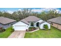 Charming single-story home featuring a manicured lawn and attached two-car garage in a friendly neighborhood at 153 Heritage Park Ln, Mulberry, FL 33860