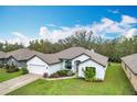 Charming home featuring a lush green lawn, attached two car garage, and inviting curb appeal at 153 Heritage Park Ln, Mulberry, FL 33860