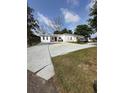 A one-story home featuring a large front yard and a spacious concrete driveway at 1771 Bayview Dr, Lakeland, FL 33805