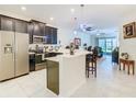 Open kitchen featuring stainless steel appliances, dark cabinetry, and a breakfast bar with seating at 2820 Attwater Loop, Winter Haven, FL 33884