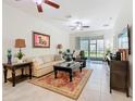 Bright living room with ceiling fans, neutral decor, and sliding glass doors to the outside at 2820 Attwater Loop, Winter Haven, FL 33884