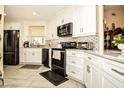 Modern kitchen featuring sleek black appliances, white cabinetry, and stylish backsplash at 3976 Cypress W Lndg, Winter Haven, FL 33884