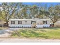 Charming manufactured home featuring a cozy front porch and well-maintained landscaping at 419 Garrett Ridge Ct, Winter Haven, FL 33880