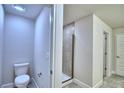 Contemporary bathroom with a toilet and tiled walk-in shower, designed for modern comfort and convenience at 4202 Teeling Ct, Auburndale, FL 33823